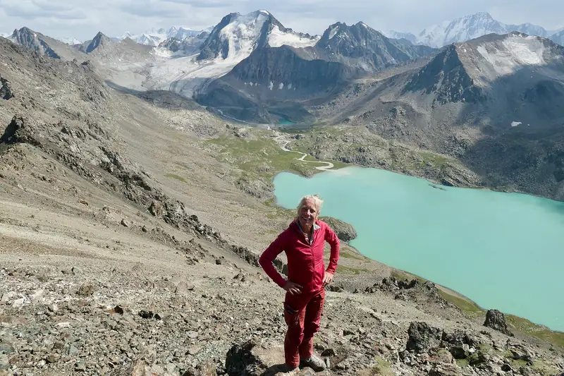 Ein Wanderer auf einem Felsgrat über dem türkisfarbenen See