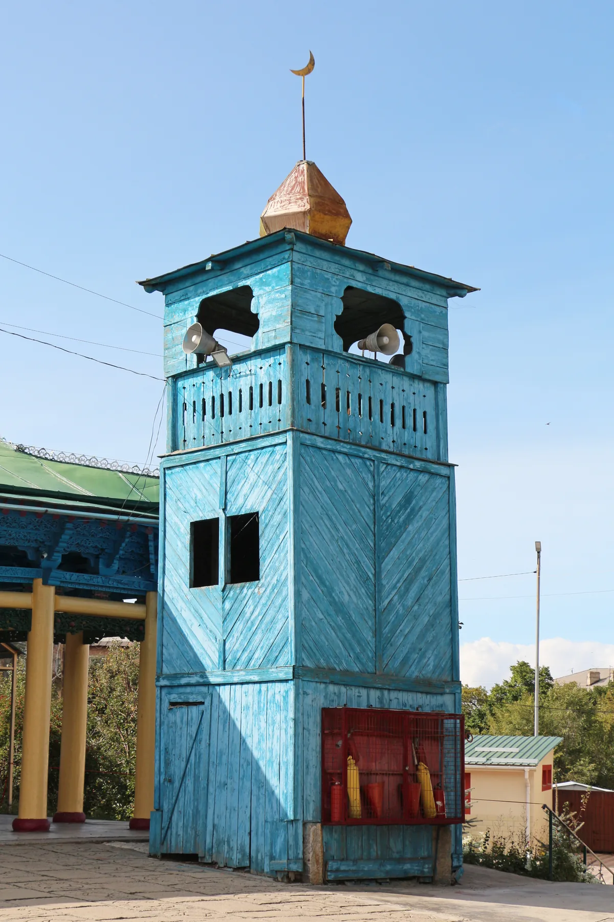 Blauer hölzerner Minarettturm mit drei Geschossen und goldener Kuppel