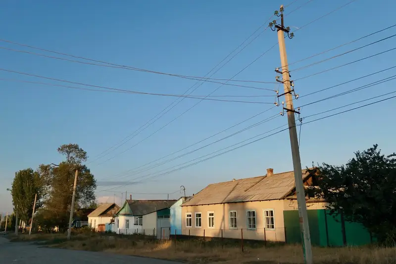Casas de un piso con techos altos y un pilar al atardecer