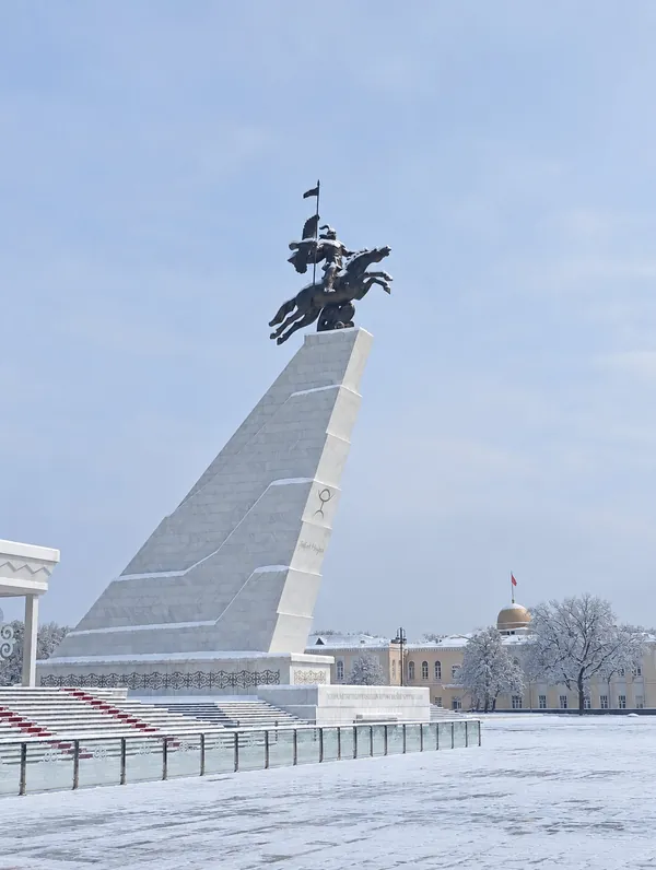 알라토 광장의 기마상. 계단과 포장도로에는 눈이 쌓여 있고 겨울 나무와 차가운 하늘이 보입니다.