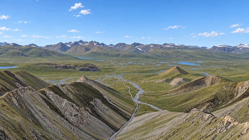 Panorama estival de la vallée de haute montagne d’Arabel, avec des lacs, des chenaux et les chaînes environnantes.