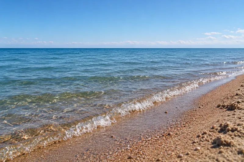 Kleine Wellen Issyk-Kul am sandigen Rand des Strandes Tscholpon-Ata aus einem niedrigen Winkel