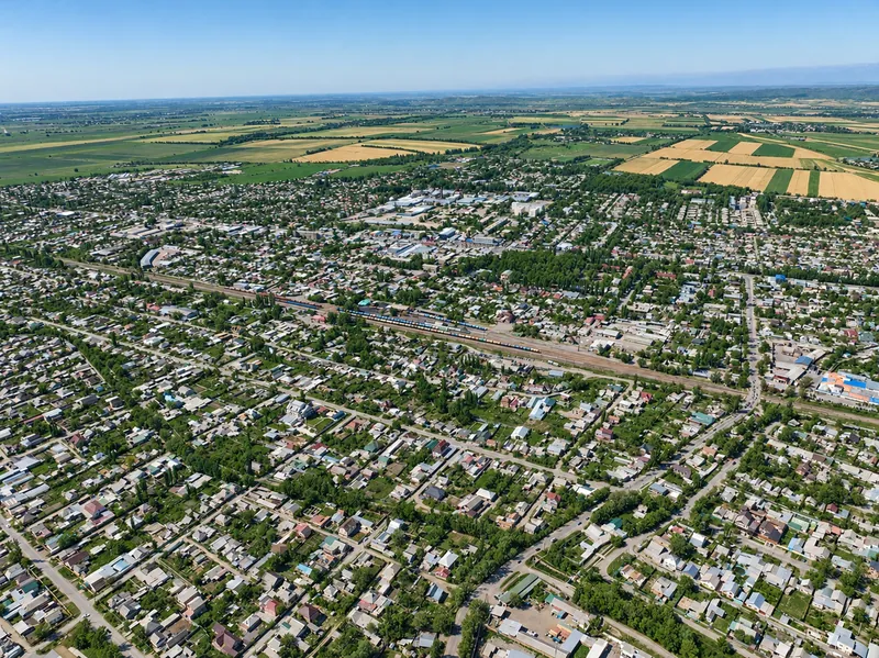 Viertel von Kant mit niedrigen Häusern und grünen Grundstücken; hinter der Stadt sieht man Felder; Sommeransicht.