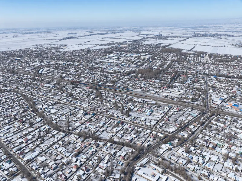 Viertel von Kant mit niedrigen Häusern und grünen Grundstücken; hinter der Stadt sieht man Felder; Winteransicht.