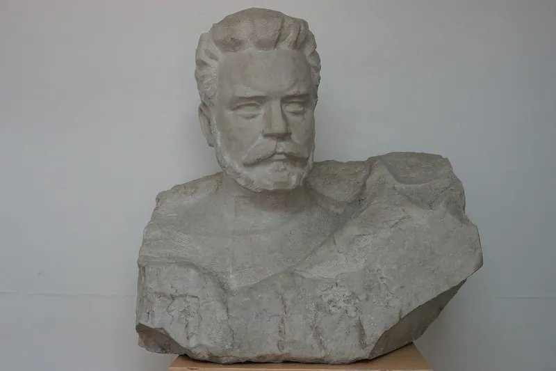 Patung dada Frunze berwarna terang di ruang museum, dengan etalase dan dinding berwarna terang di belakangnya.