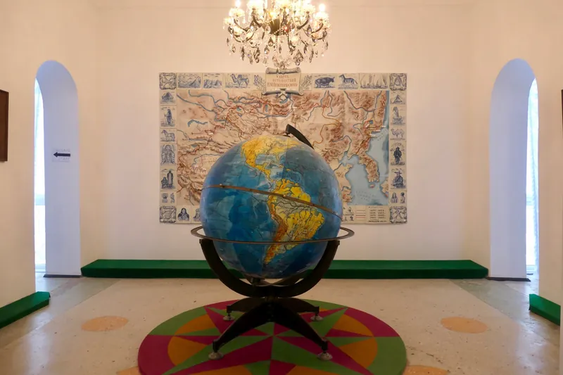 Un grande globo al centro di una sala del museo, con una mappa e due passaggi ad arco sullo sfondo.