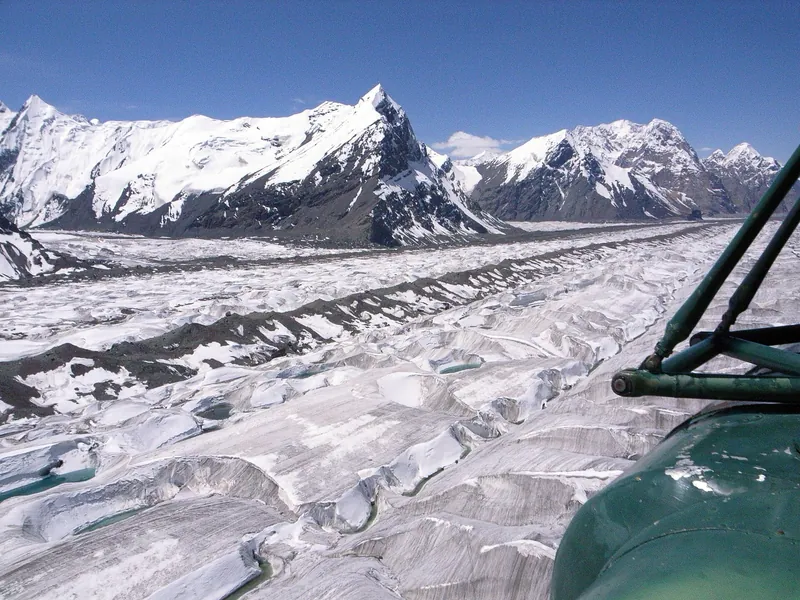 Engilchek Glacier from a Mi-8 helicopter: dark moraine stripes on white ice and mountain ridges