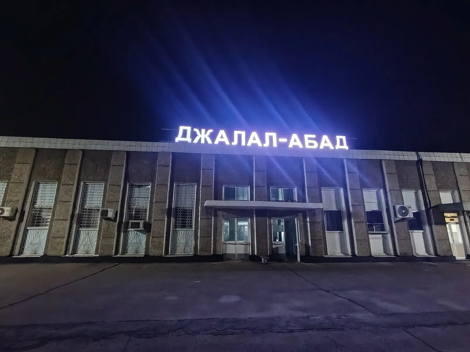 Fachada nocturna de la estación de tren, con un letrero luminoso sobre la entrada principal.