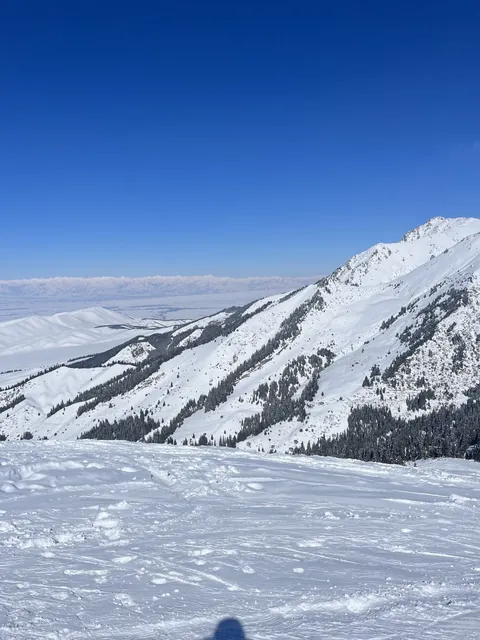 Poste d'observation enneigé de la station amont : versants des montagnes et vue lointaine vers le lac.