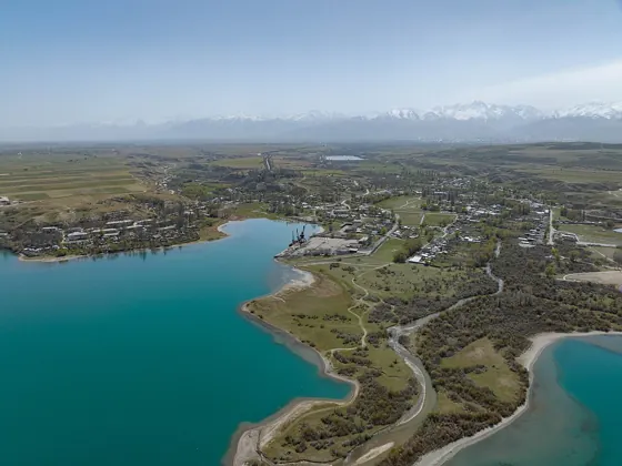 Eine Bucht des Issyk-Kul bei Pristan und verschneite Berge